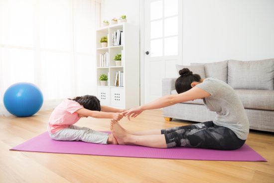 A mother and daughter do yoga together for a stock photography shoot