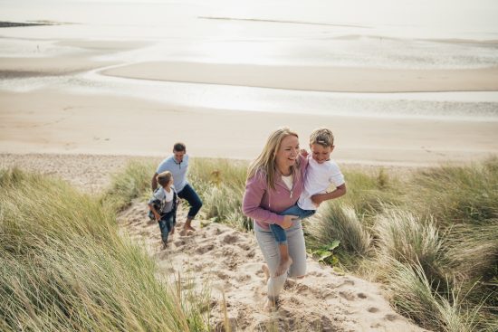 Active lifestyle stock photo showing a happy family on a walk at the beach