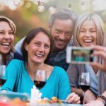 stock photography showing friends getting their photo taken at a dinner party