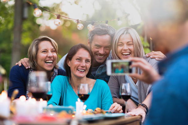 Stock photo showing friends posing for a photo at a dinner party